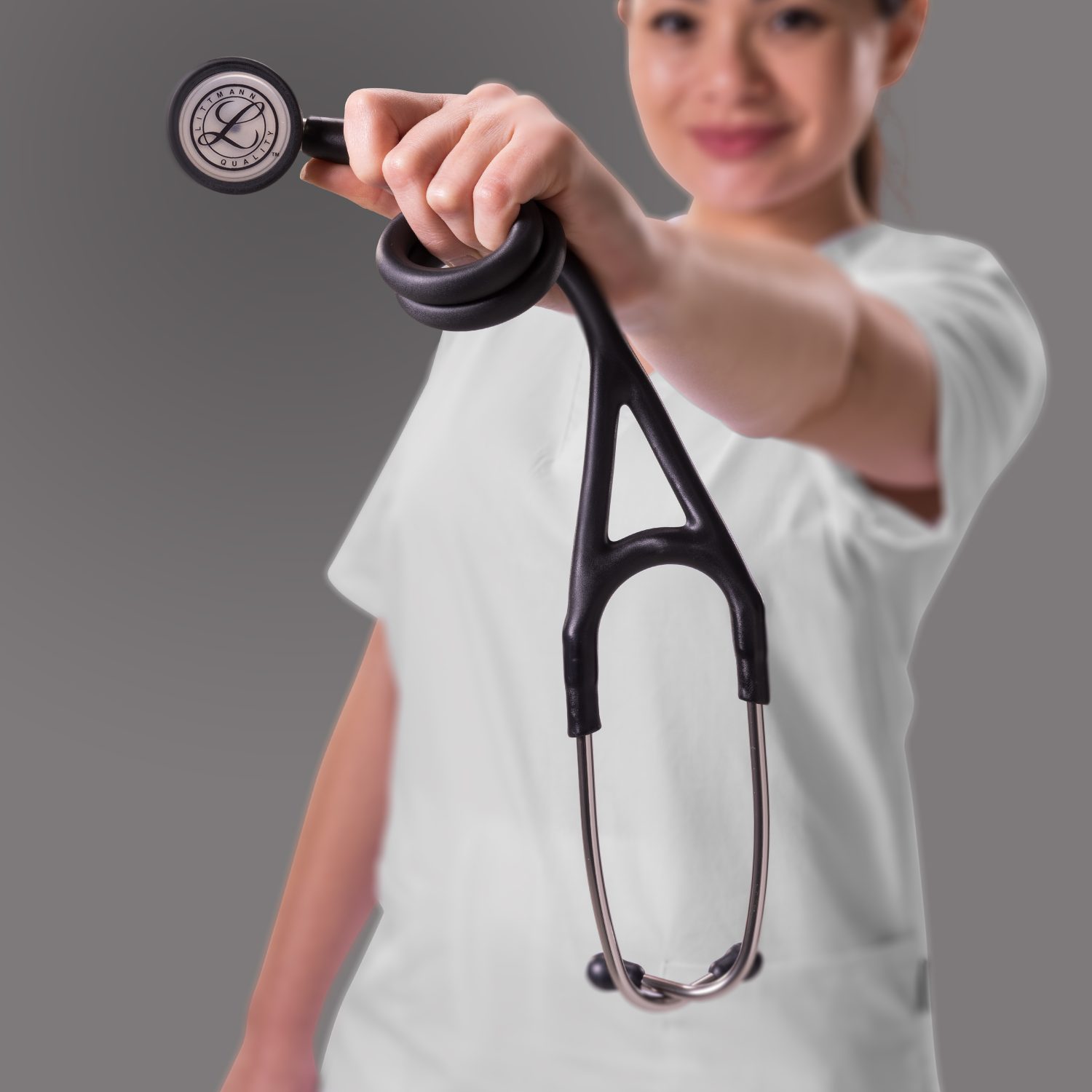 רופאה מציגה קדימה פעמון מראה סטטוסקופ ליטמן קרדיולוגי 4 שחור סאטן 6177C על רקע אפור